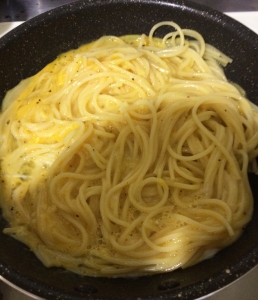 フライパンで溶き卵とベーコン、粉チーズ、黒コショウを加えて手早く混ぜる